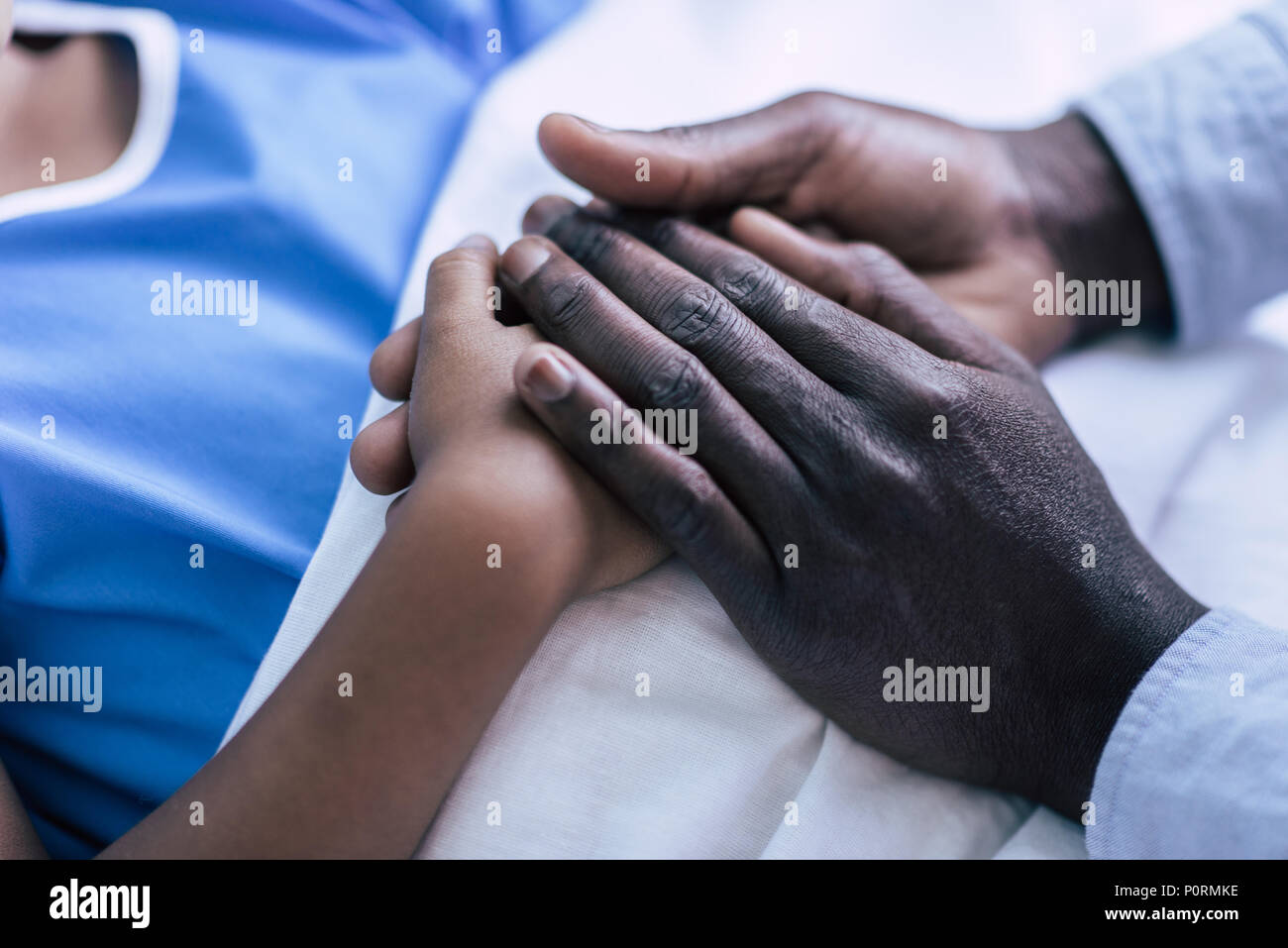 partial view of african american father and son holding hands together ...