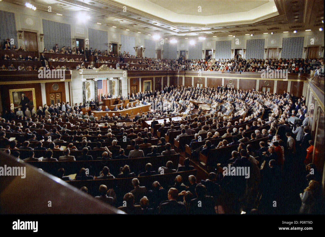 1975, January 15 – United States Capitol - House Chamber – Gerald R. Ford, Rockefeller, Rep. Albert, Clerks, Congressmen & Women, Others – GRF speaking at podium, gesturing; others seated, listening - long shot taken from Gallery – State of the Union Address Stock Photo