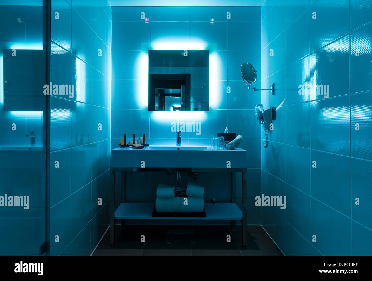 Modern bathroom interior with flashy blue lights in the modern city center of La Paz. Stock Photo