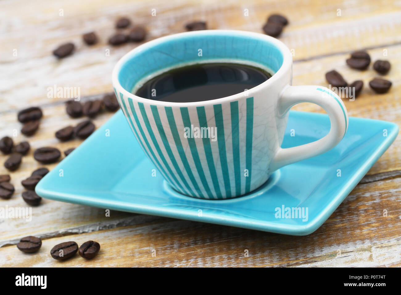 Espresso coffee in vintage blue and white striped cup on rustic wooden surface Stock Photo