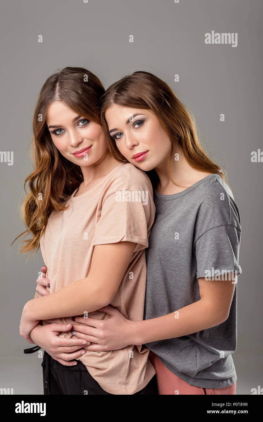 Portrait of beautiful twin sisters hugging each other and Portrait of beautiful twin sisters hugging each other and