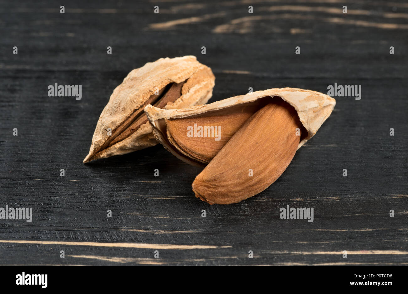 Wild uzbek inshell almonds on dark table Stock Photo