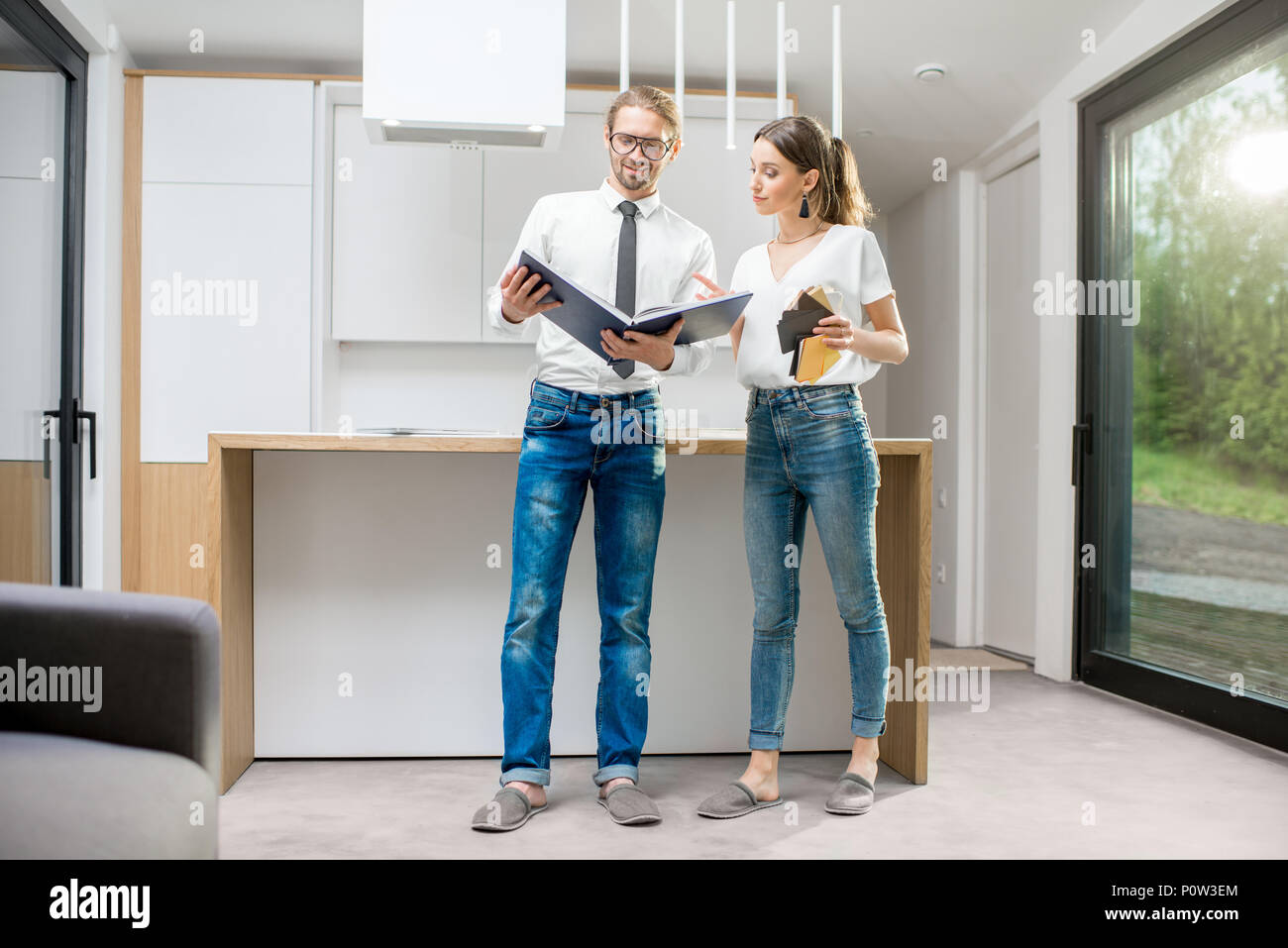 Young couple with book in the modern kitchen interior Stock Photo