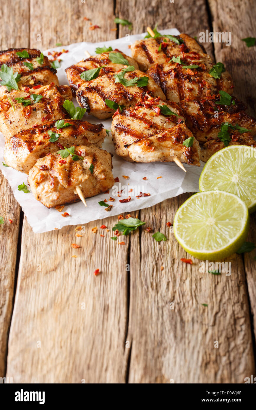 Afghan chicken skewers  Kebab e Murgh close-up on paper on table. vertical Stock Photo