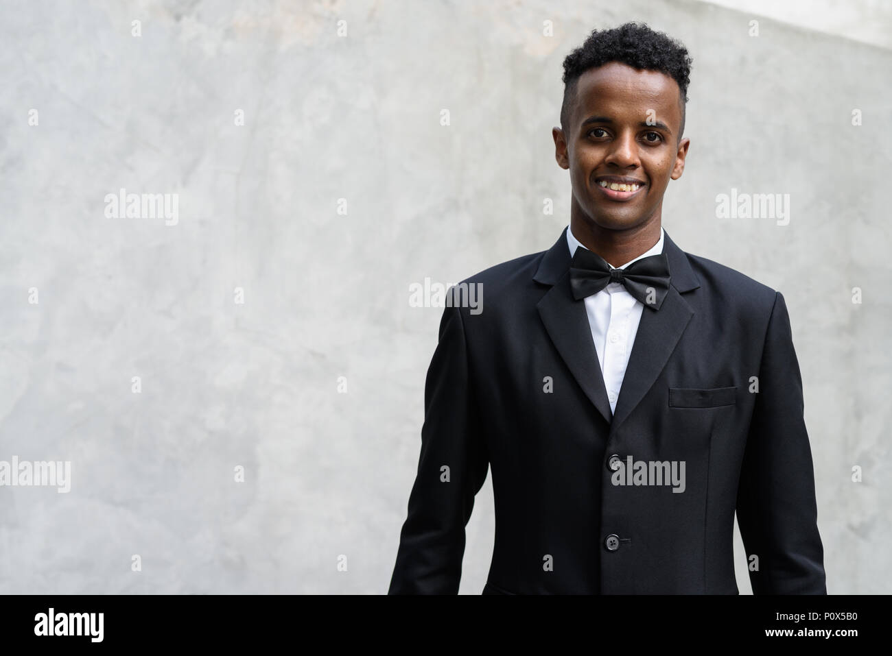 Young handsome African businessman wearing suit against concrete Stock ...