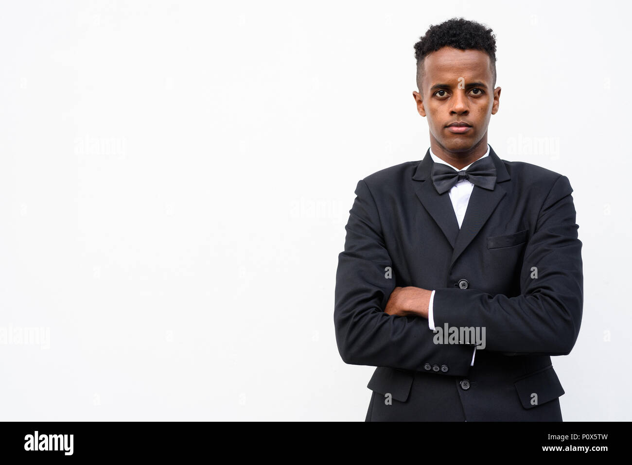Young handsome African businessman wearing suit against white ba Stock ...