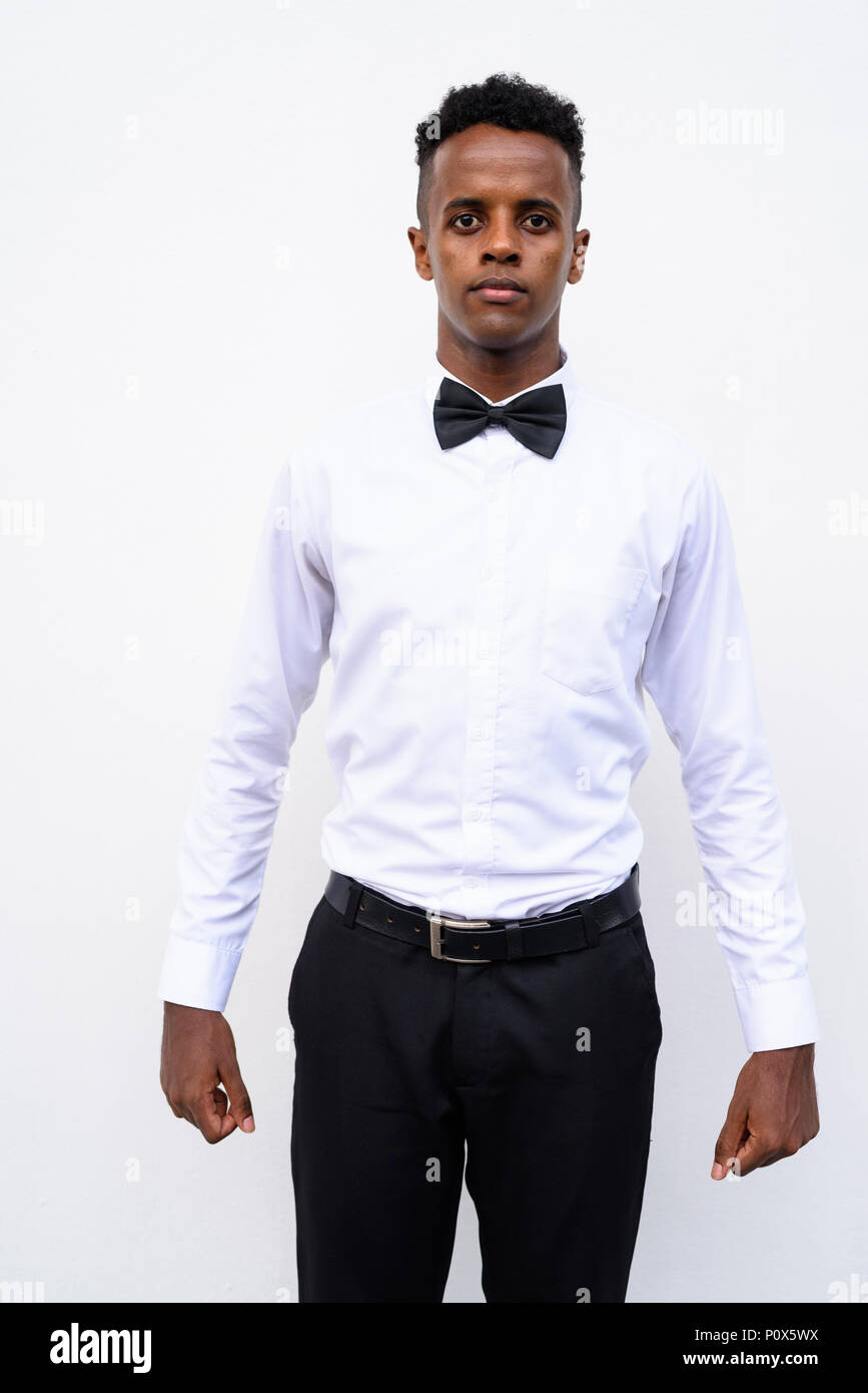 Young handsome African businessman wearing bow tie against white Stock Photo