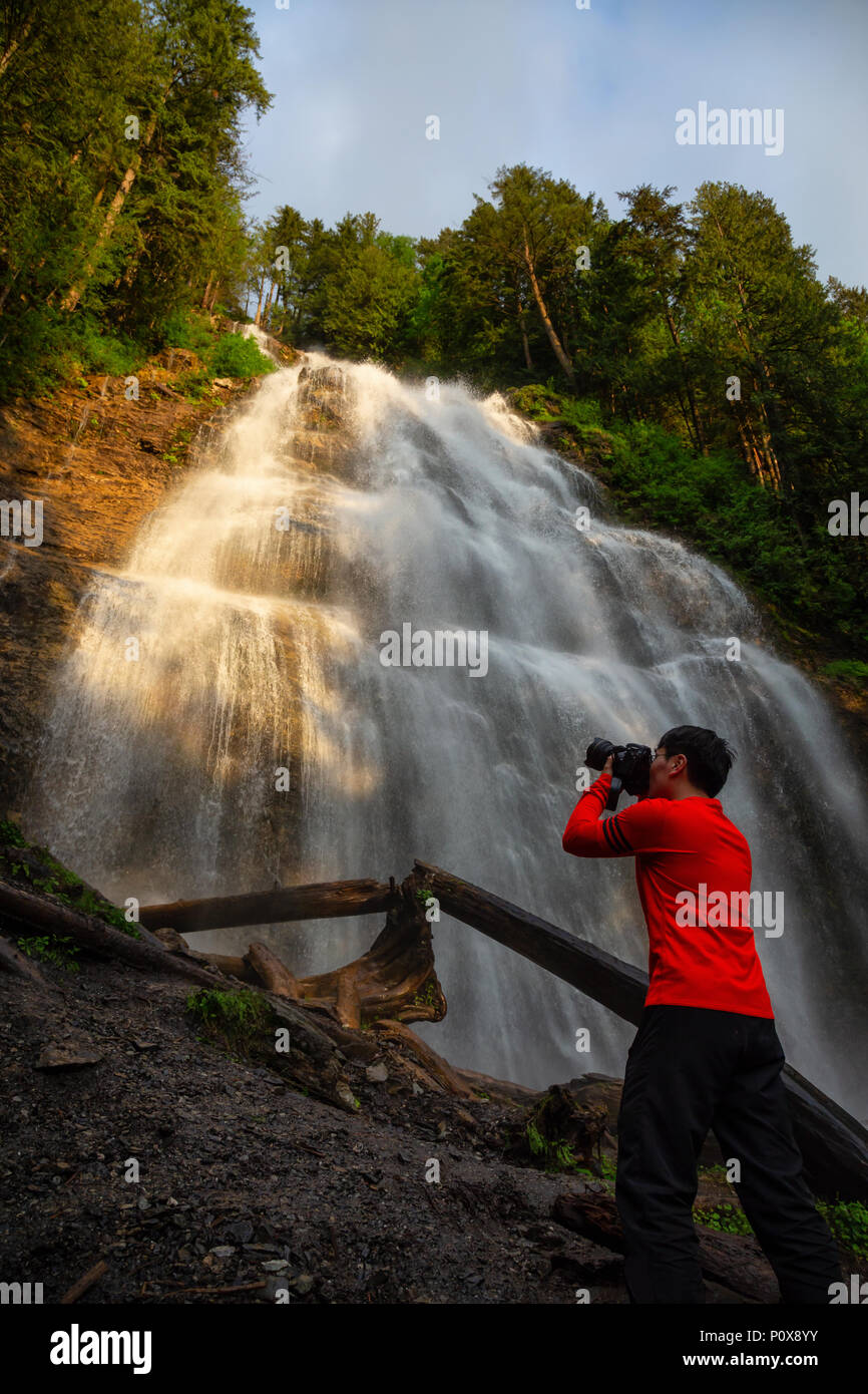 Man enjoying the beautiful waterfall. Taken in Bridal Veil Falls Provincial Park near Chilliwack, East of Vancouver, British Columbia, Canada. Stock Photo