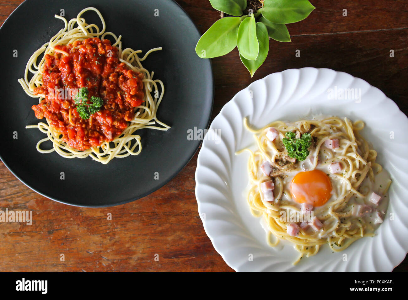 Spaghetti Carbonara with egg yolk and Spaghetti italian pasta with tomato sauce on wooden table