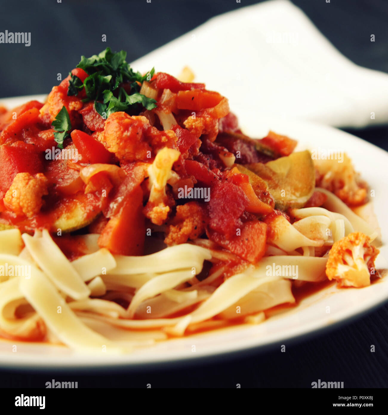 Ribbon pasta with Arrabiata sauce. Close up. Mediterranean dish. Tagliolini pasta with vegetables. Cauliflower, courgette and tomato stew. Italian cui Stock Photo