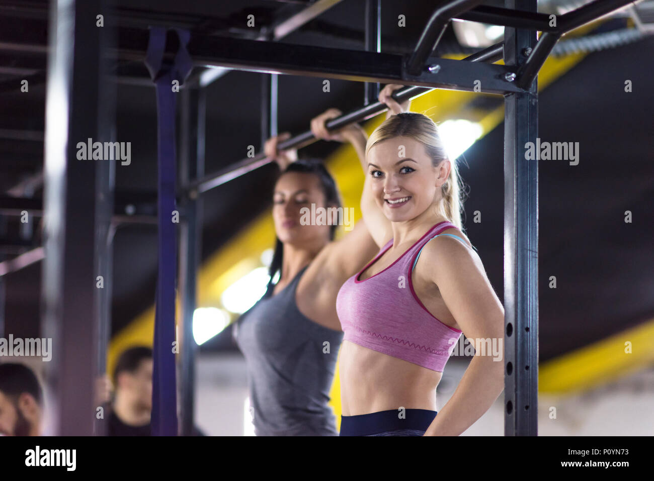 group of young muscular athletes doing pull ups on the horizontal bar ...