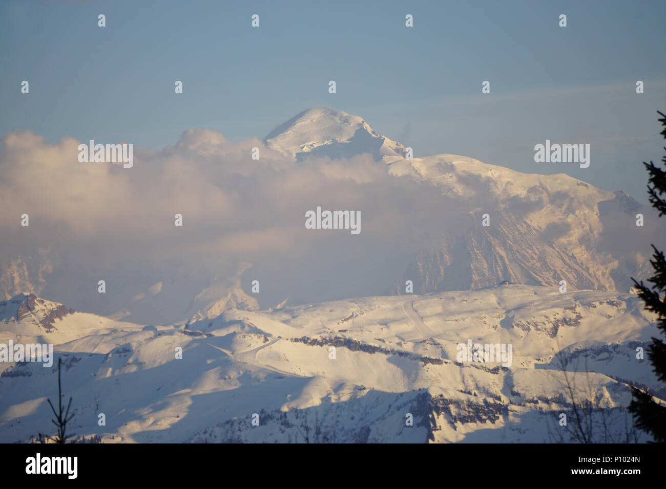 Sun setting on the Mont Blanc with clouds hovering on a beautiful winter day Stock Photo