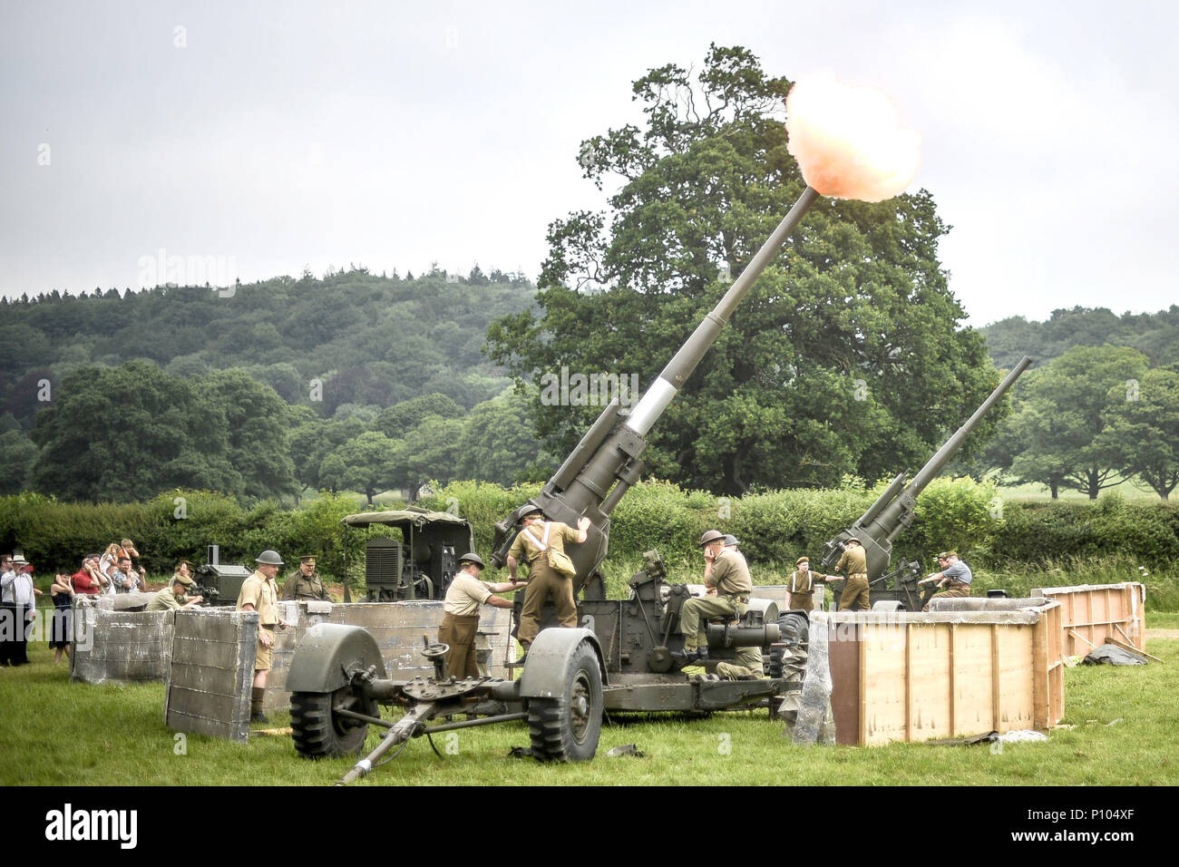 Men dressed as WWII soldiers fire anti-aircraft guns during an air-raid firing demonstration at the Dig for Victory Show, a festival that celebrates the 1940's, at the North Somerset Ground, Wraxall, Somerset. Stock Photo