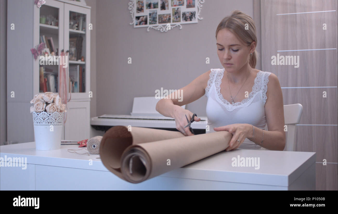 Young woman cutting wrapping paper Stock Photo