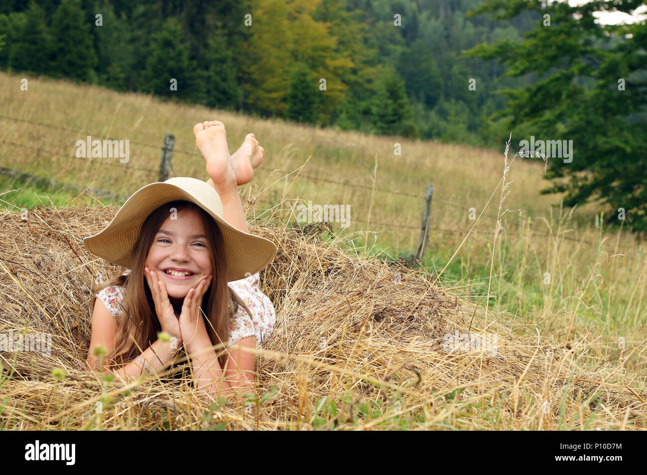 happy little girl lies in the hay Stock Photo