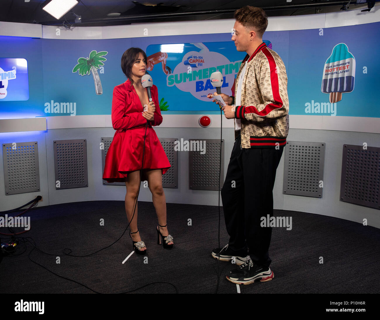 Camila Cabello and Roman Kemp in the on air studio during Capital's Summertime Ball with Vodafone at Wembley Stadium, London. PRESS ASSOCIATION Photo. This summer's hottest artists performed live for 80,000 Capital listeners at Wembley Stadium at the UK's biggest summer party. Performers included Camila Cabello, Shawn Mendes, Rita Ora, Charlie Puth, Jess Glyne, Craig David, Anne-Marie, Rudimental, Sean Paul, Clean Bandit, James Arthur, Sigala, Years & Years, Jax Jones, Raye, Jonas Blue, Mabel, Stefflon Don, Yungen and G-Eazy. Picture date: Saturday June 9, 2018. Photo credit should read: Laure Stock Photo