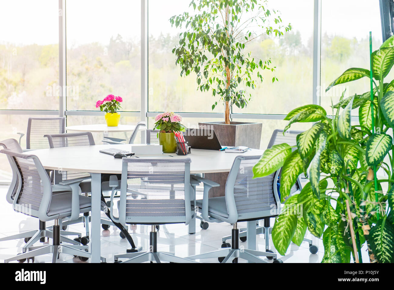 Round table as work place with laptop, notebooks in modern light open