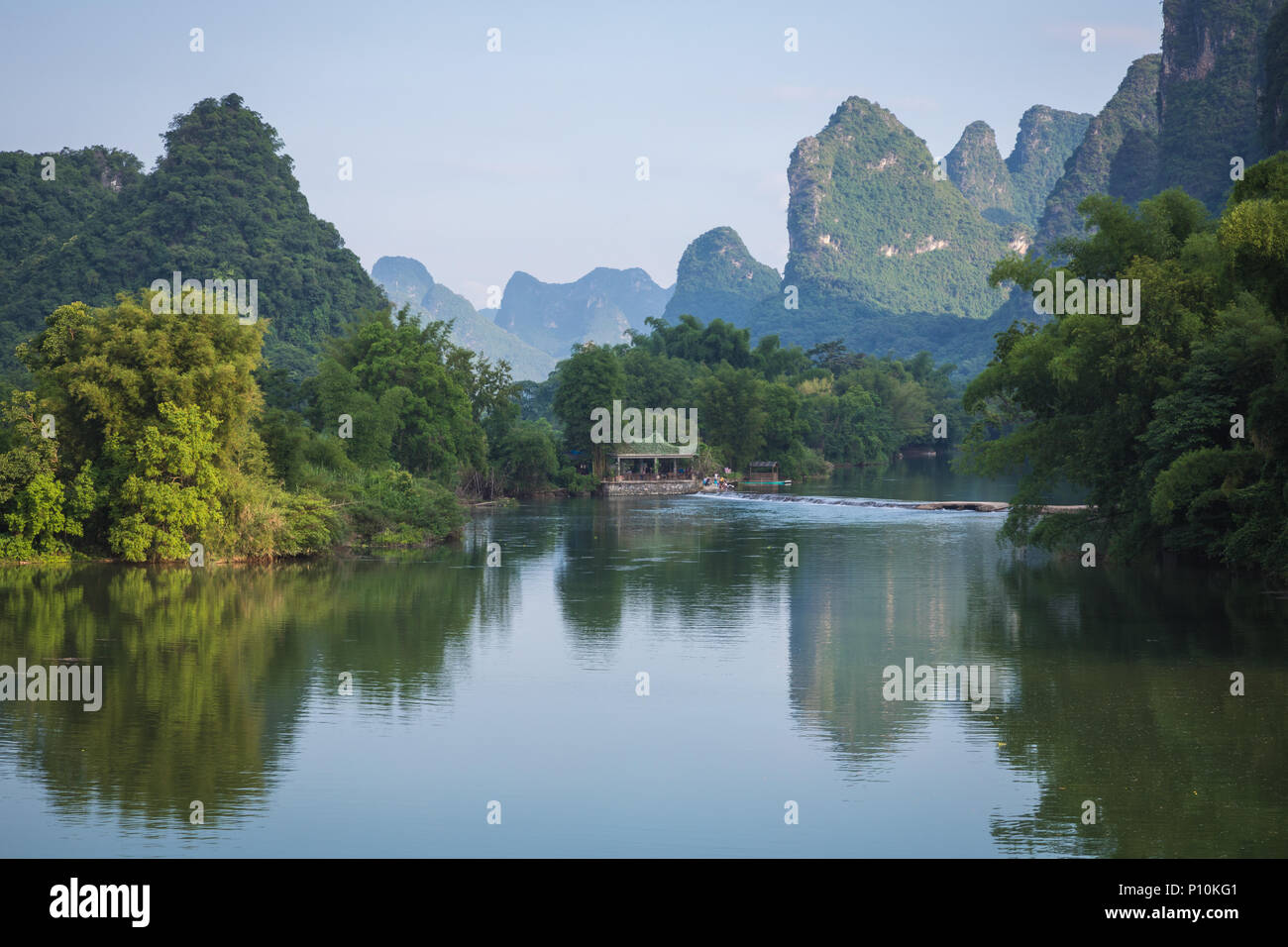 Scenic view of Yulong River among green woods and karst mountains at Yangshuo County of Guilin, China. Yangshuo is a popular tourist destination of As Stock Photo