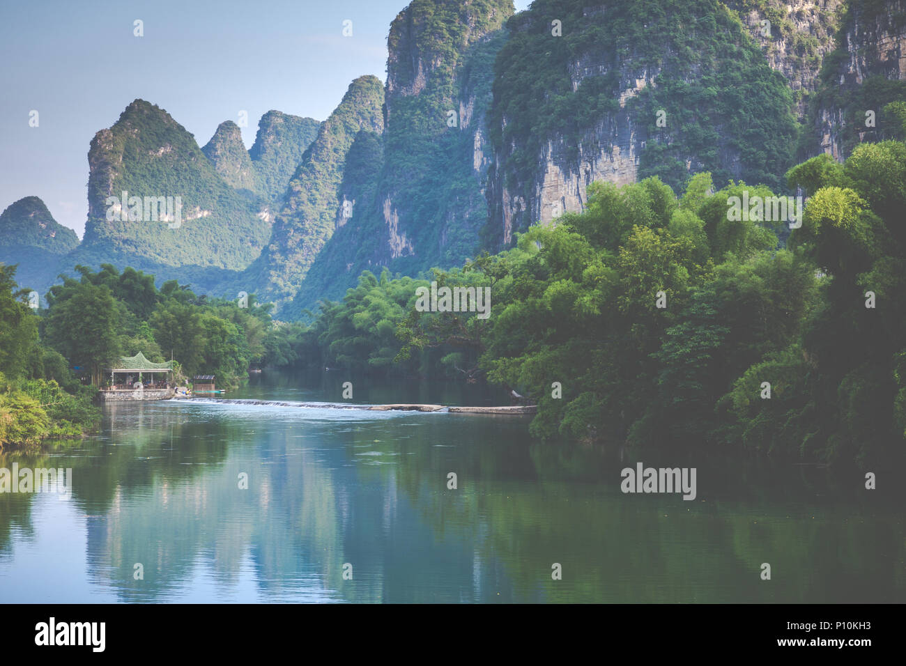 Scenic view of Yulong River among green woods and karst mountains at Yangshuo County of Guilin, China. Yangshuo is a popular tourist destination of As Stock Photo