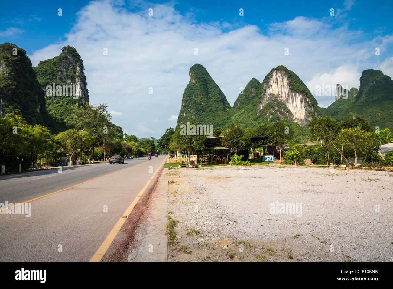 Scenic summer sunny landscape at Yangshuo County of Guilin, China. View of beautiful karst mountains Amazing green hills on blue sky background. Stock Photo