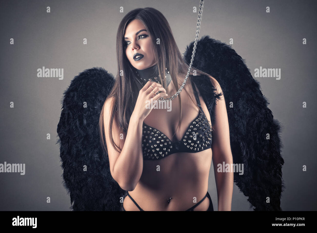 sexy brunette woman slave with black wings Stock Photo - Alamy