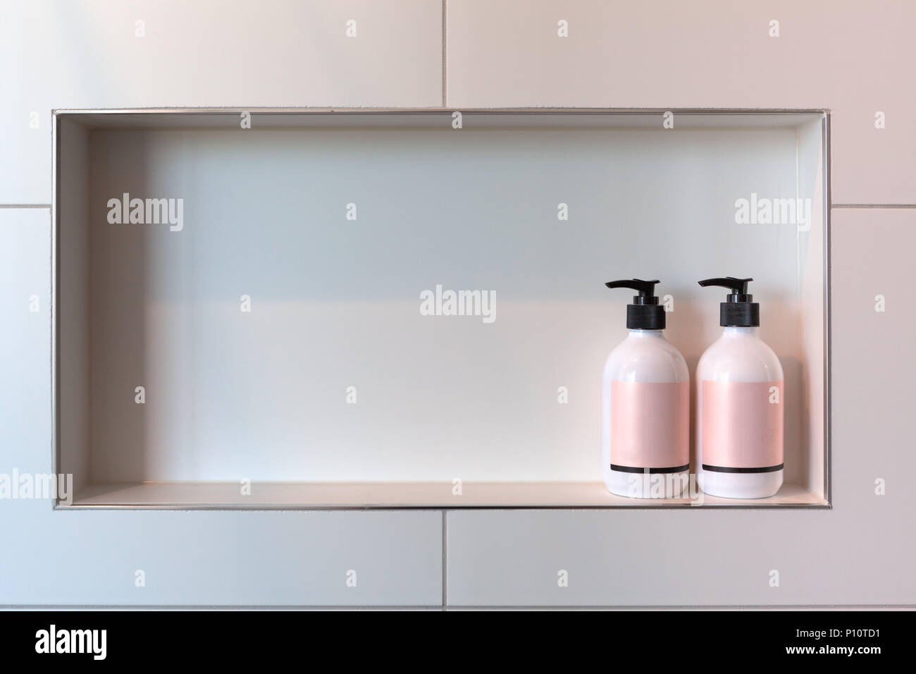 Shampoo and conditioner or shower gel dispensers in a rectangular niche made of white tiles with