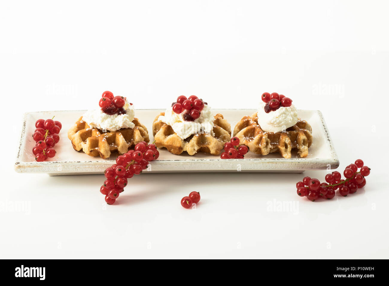 Butterwaffeln mit Sahne und Johannisbeeren, Freisteller Stock Photo