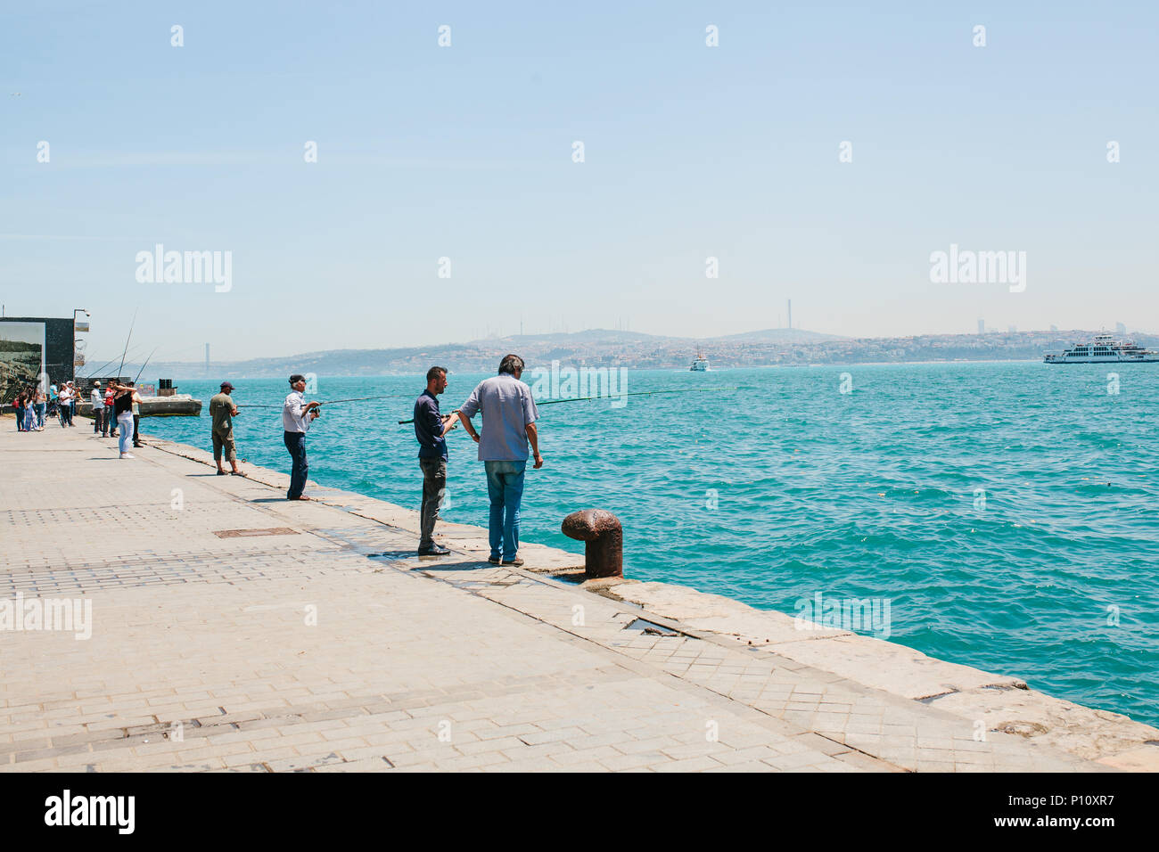 2 Guys talking on a wall waiting to cross the Bosphorus, Istanbul, Turkey
