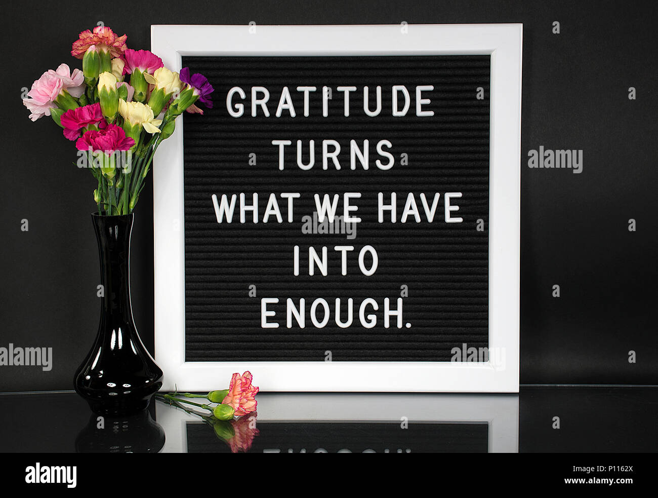 inspiration quote about gratitude on message board with carnation bouquet in black vase Stock Photo