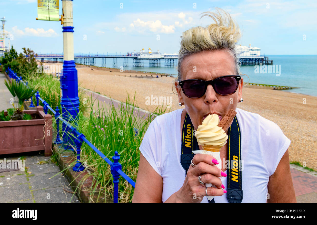 Middle aged woman eating ice cream at the seaside Stock Photo