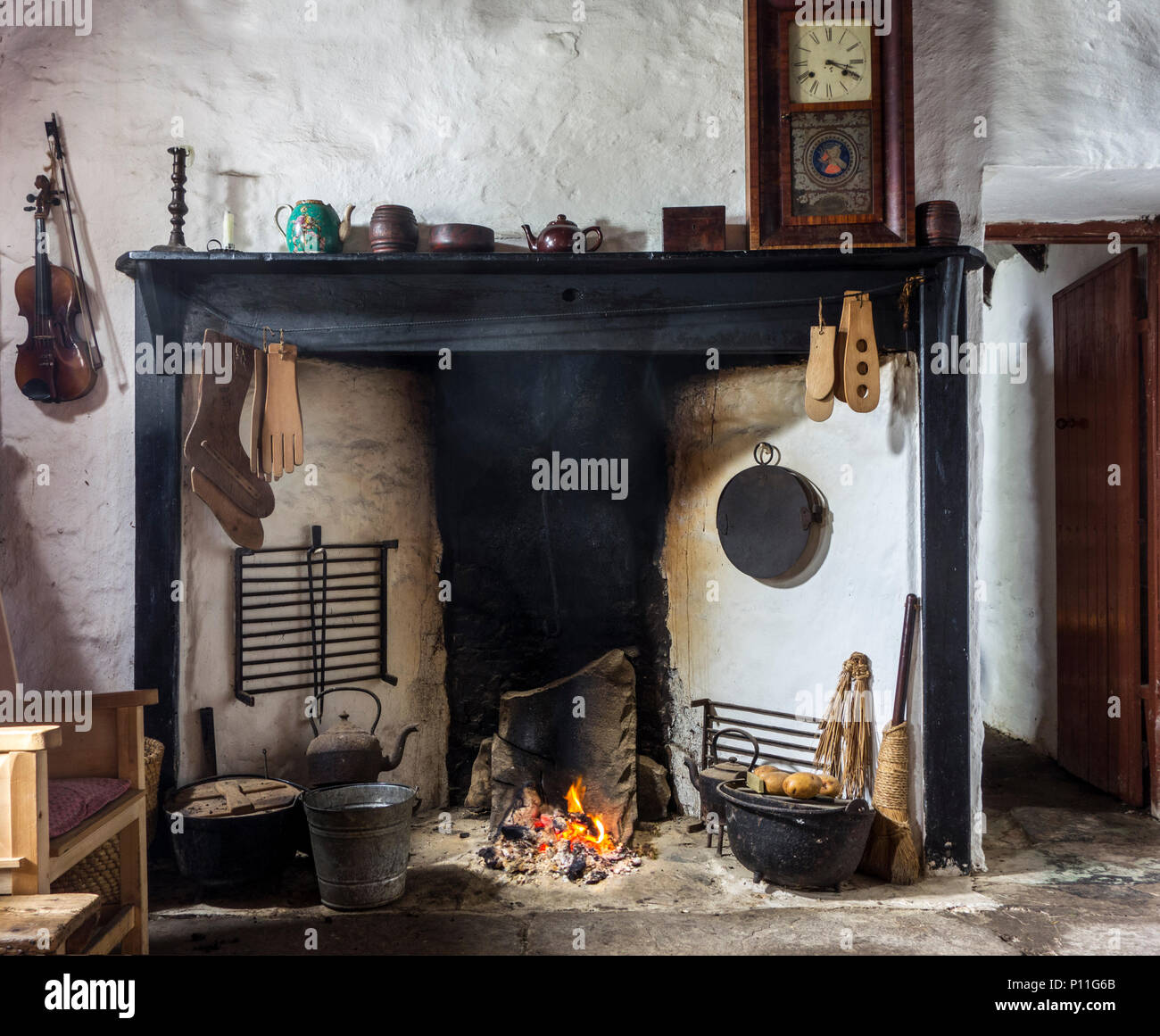 Peat fire burning in fireplace at the Croft House Museum / Crofthouse Museum, restored 19th century cottage at Boddam, Shetland Islands, Scotland, UK Stock Photo