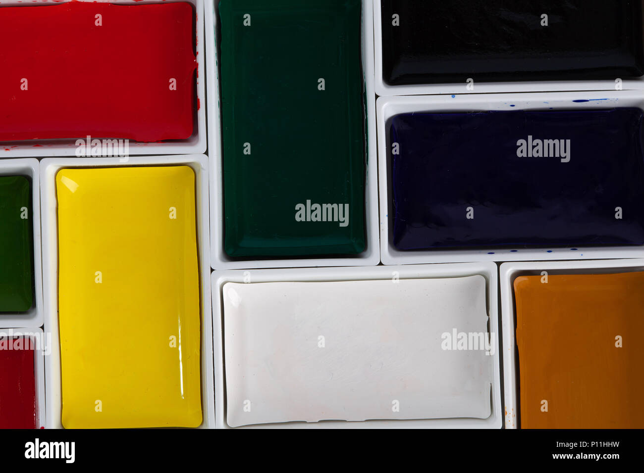 Solid watercolor pans arranged in jigsaw puzzle top view with copy space Stock Photo