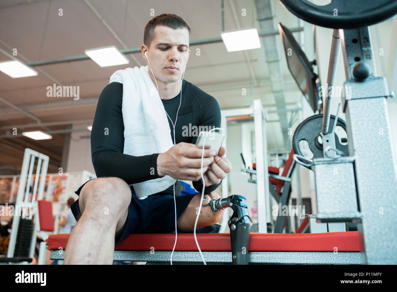 Man with smartphone in gym Stock Photo