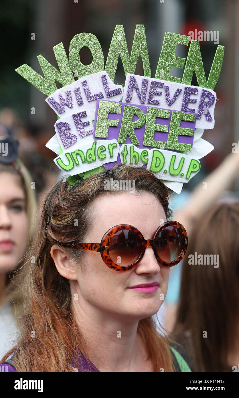 A woman wearing a hat critical of the Democratic Unionist Party takes part in the Processions' artwork march, in Belfast, as they mark 100 years since the Representation of the People Act which gave the first British women the right to vote and stand for public office. Stock Photo