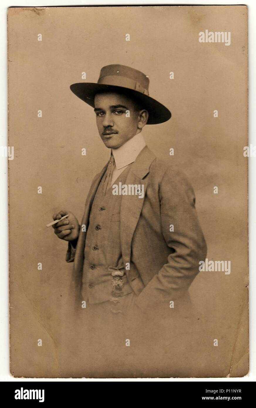 OLOMOUC, THE CZECHOSLOVAK REPUBLIC - CIRCA 1920s: Vintage photo shows dandy man with cigarette and hat. Antique black white photo. Stock Photo