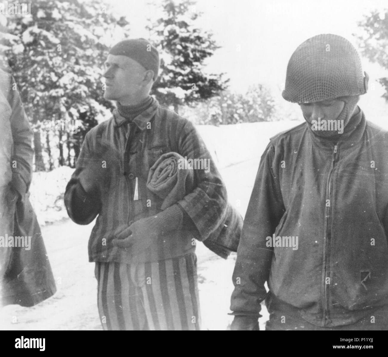 Tahae Sugita (right), a Japanese-American soldier with the 522nd Field Artillery battalion, stands next to a concentration camp survivor he has just liberated on a death march from Dachau in May 1945. Stock Photo