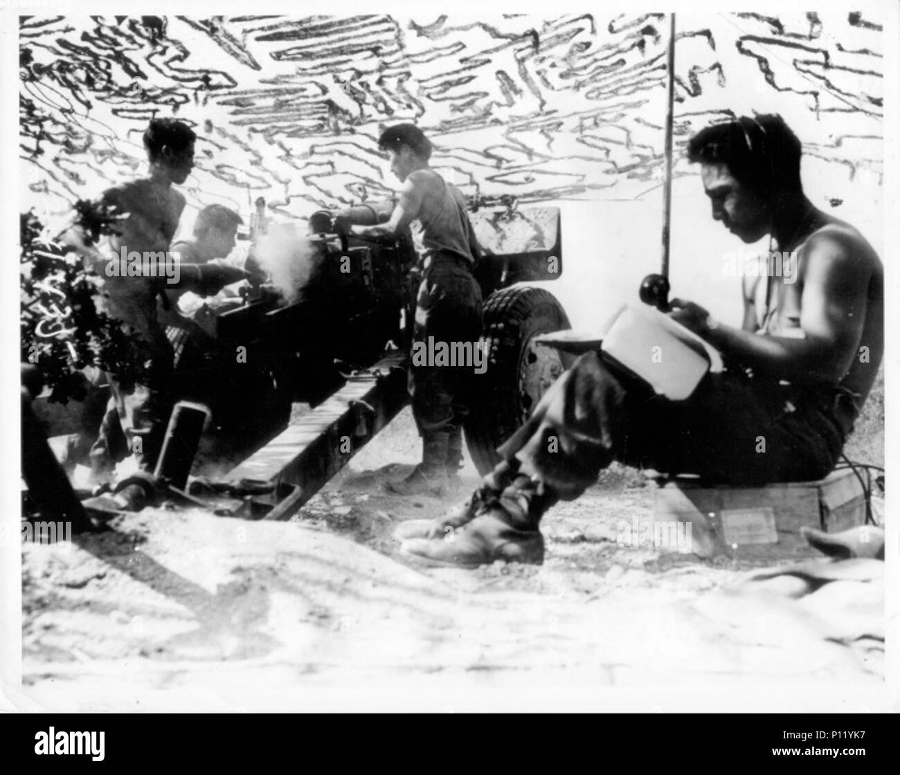 Soldiers of the 522nd Field Artillery Battalion firing a 105MM