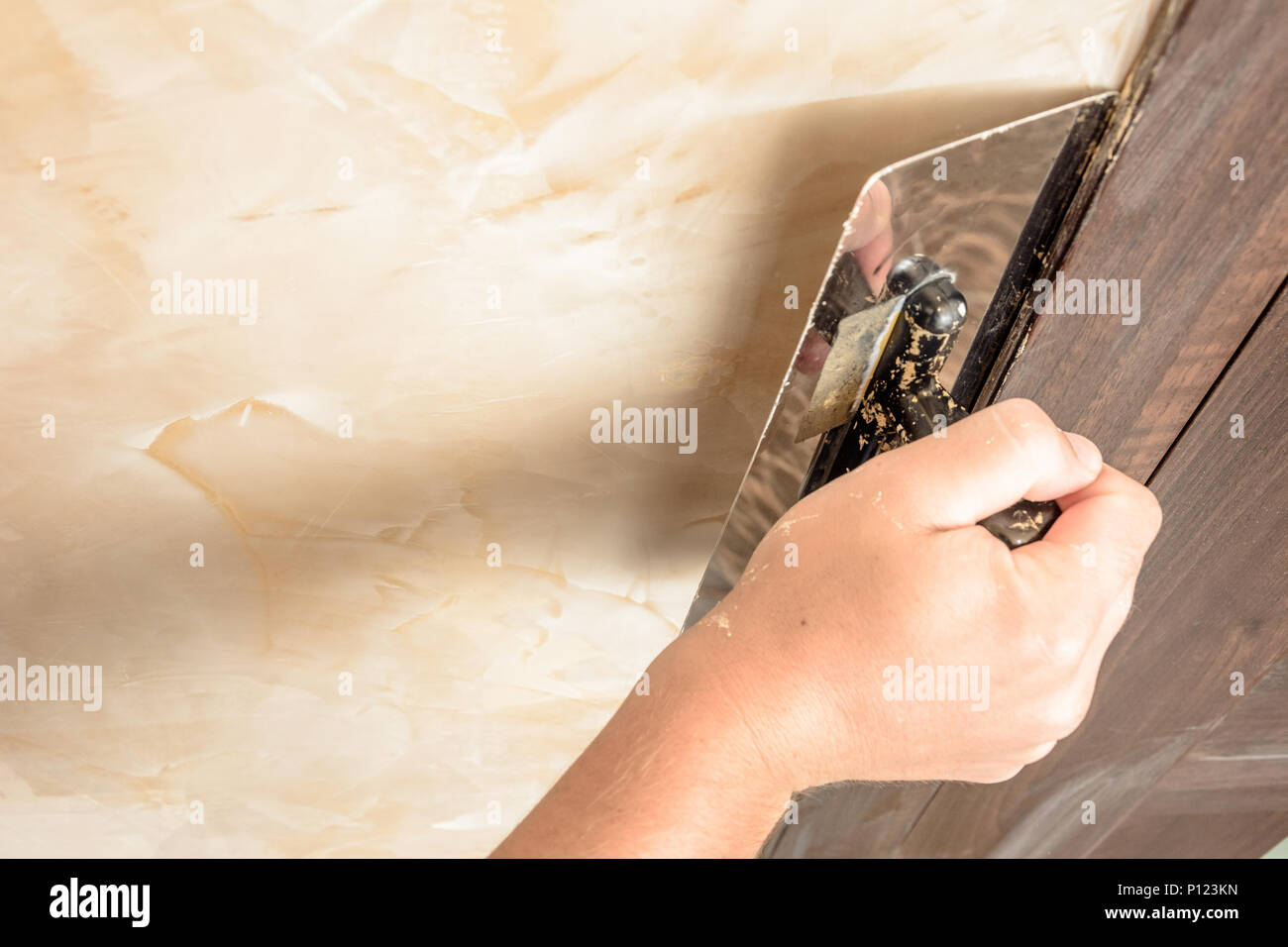 Stretching the second layer of Venetian plaster by man 2018 Stock Photo