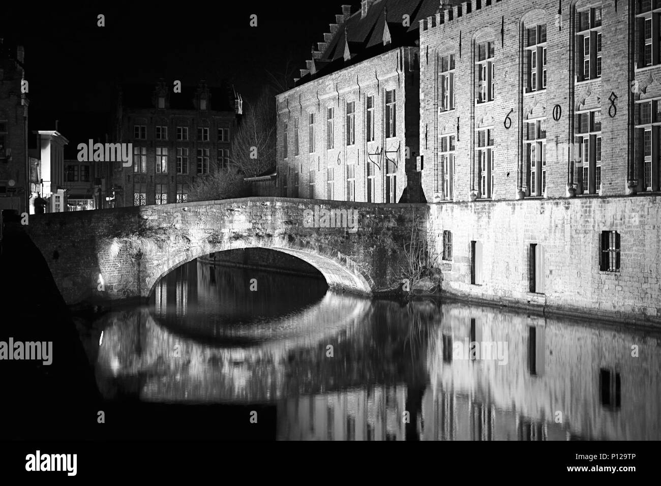 Blinde Ezelbrug over the Groenerei canal from Steenhouwersdijk, Brugge, Belgium: completely empty on a winter's night : black and white version Stock Photo
