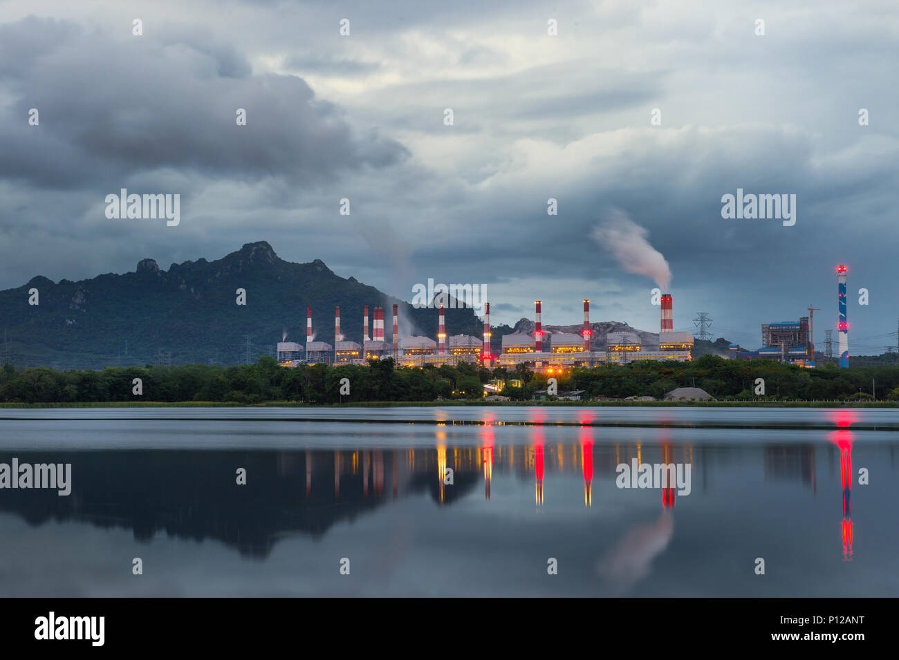 Industrial power plant with smokestack near the river. Stock Photo