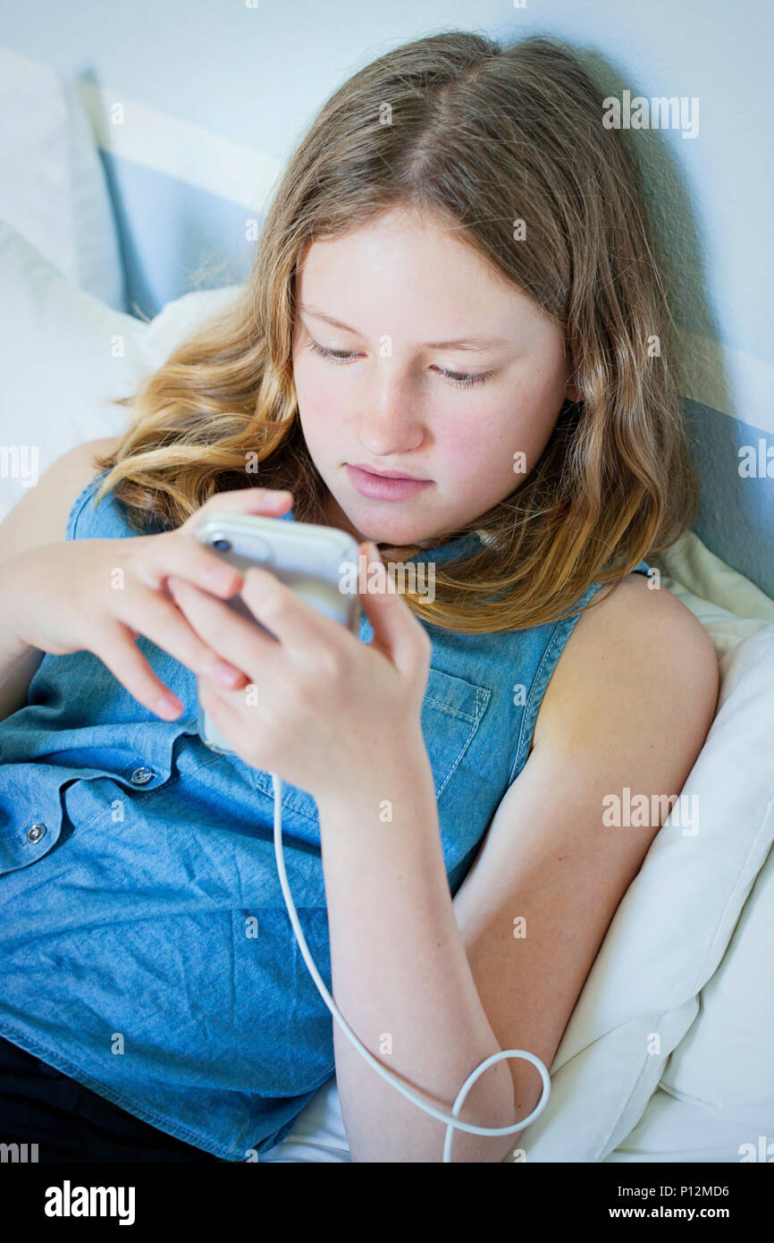 Twelve year old girl using iPhone cell phone Stock Photo