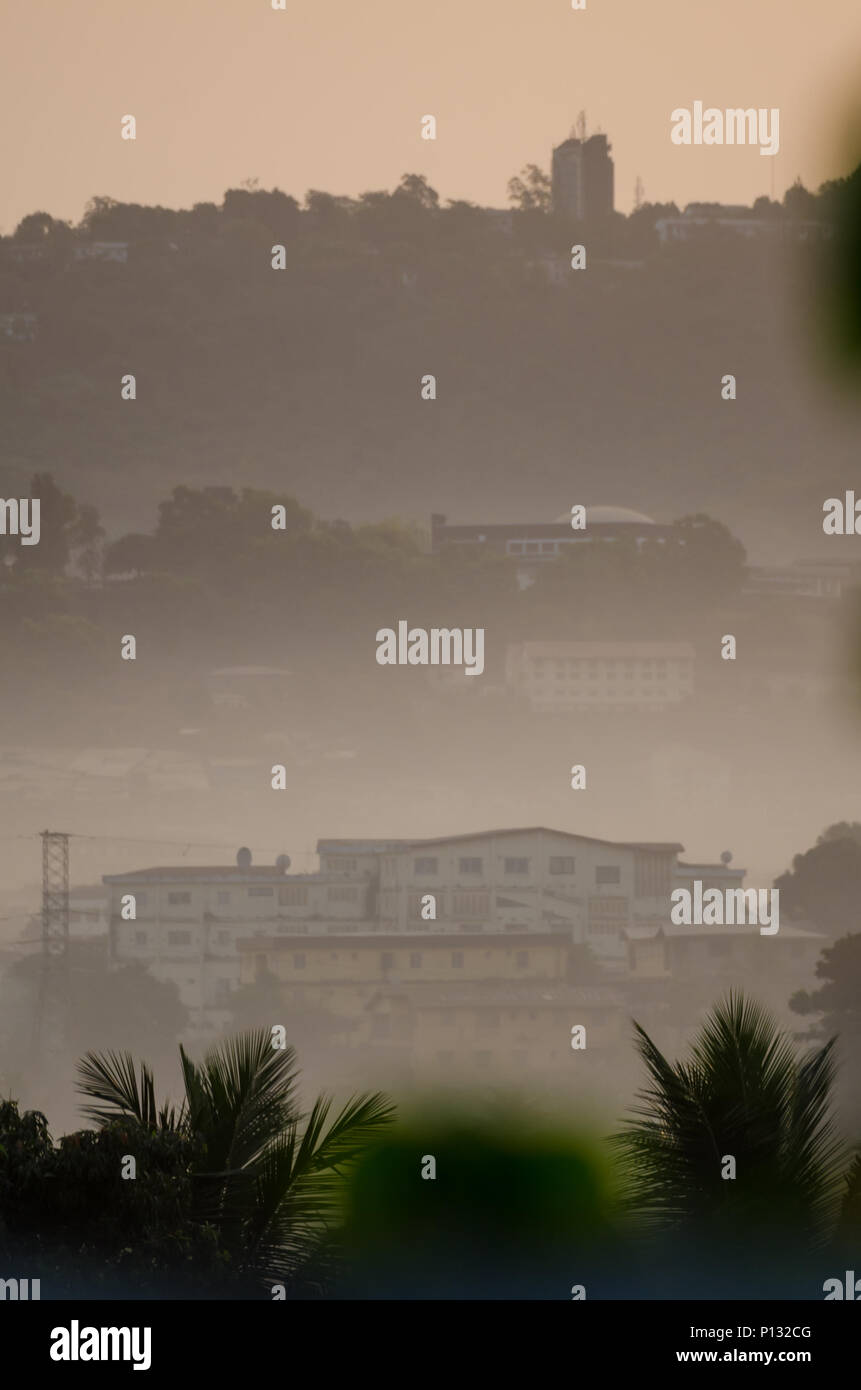 The capital of Sierra Leone Freetown during early morning fog with misty mountains and green foreground Stock Photo