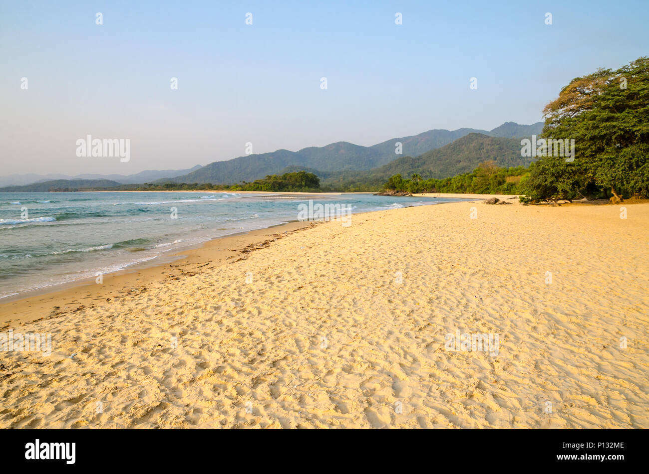 Beautiful Bureh Beach in the afternoon with yellow sand, green trees, sea and mountains, Sierra Leone, Africa Stock Photo