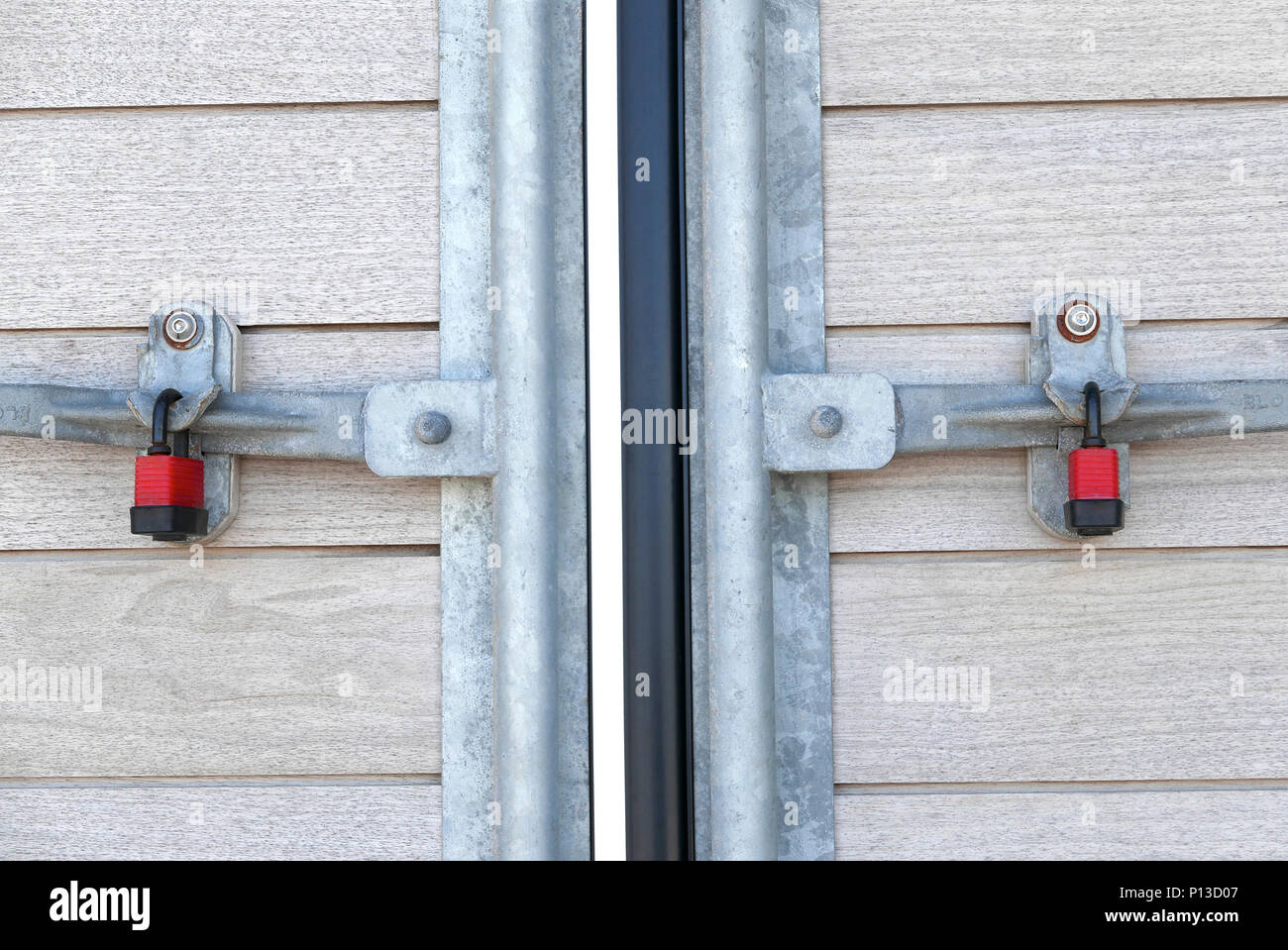Two Red Padlocks Attached To Double Locking Wooden Door Stock