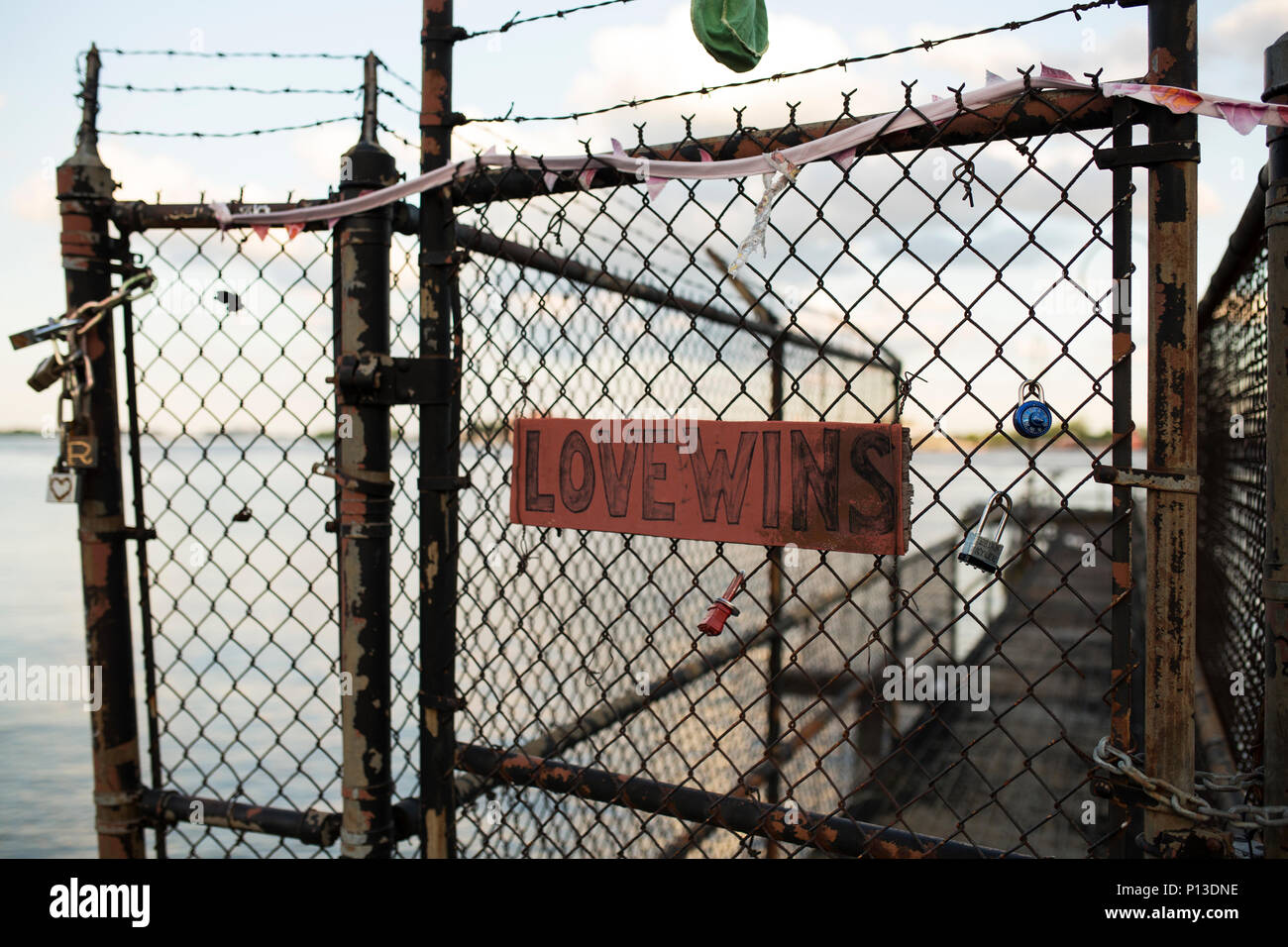 A handwritten Love Wins sign on a chain link fence along the Mississippi River in New Orleans, Louisiana. Stock Photo