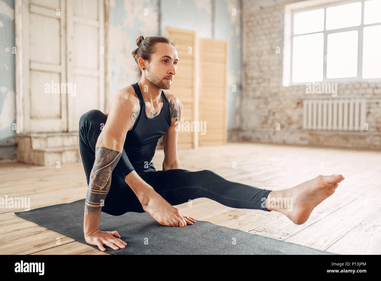 Male yoga relax in gym, balance exercise on mat. Fitness workout