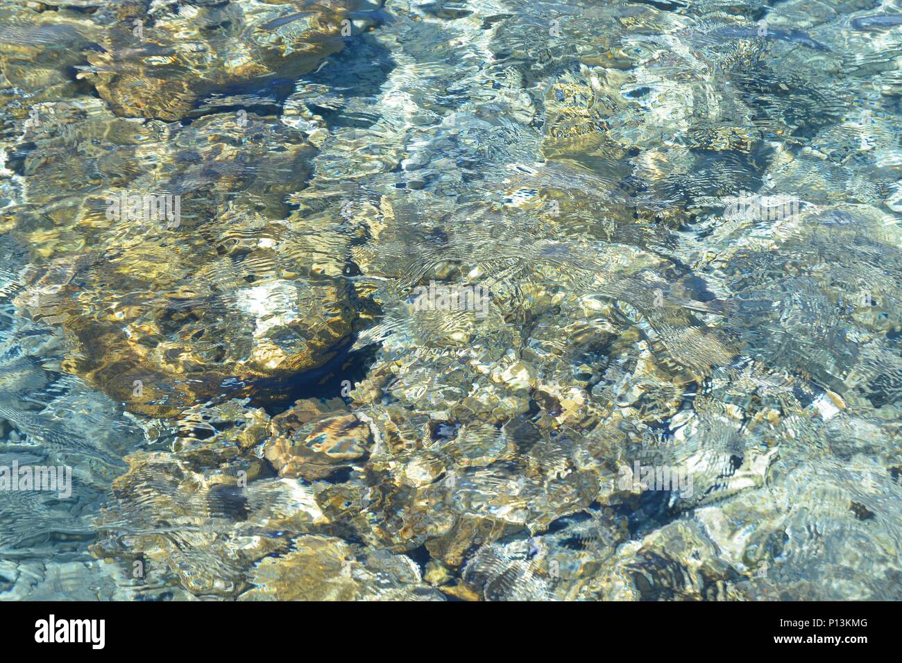 Sea water Pebbles and rocks on beach with pure blue transparent water ...