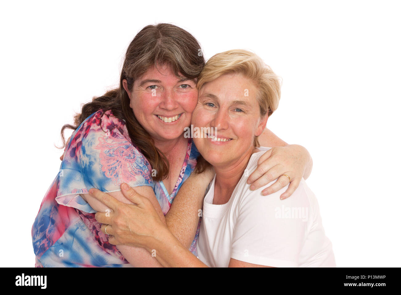 Two close friends hugging for a photo, real middle aged women. Stock Photo
