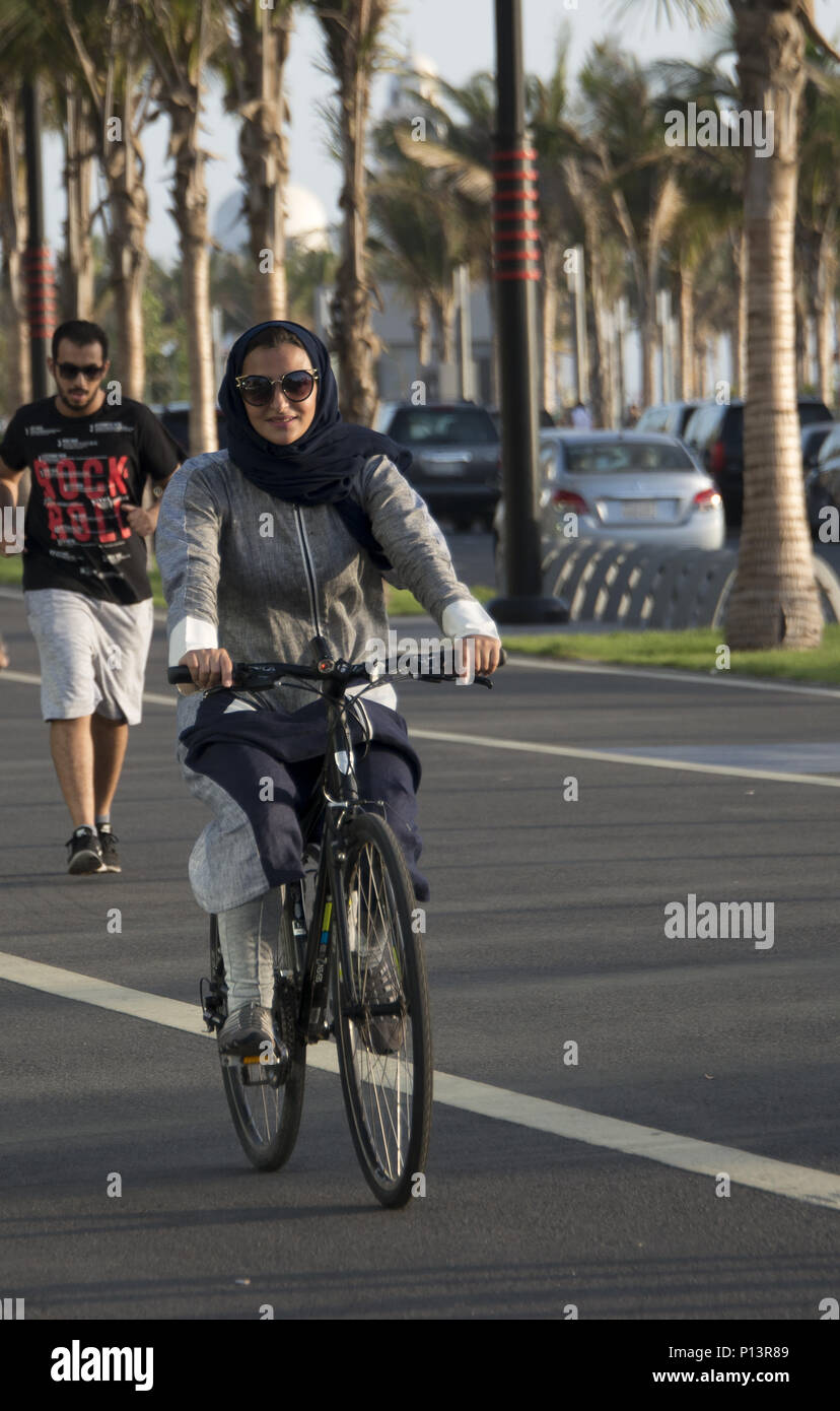 Saudi woman riding a bicycle in Jeddah, Saudi Arabia Stock Photo