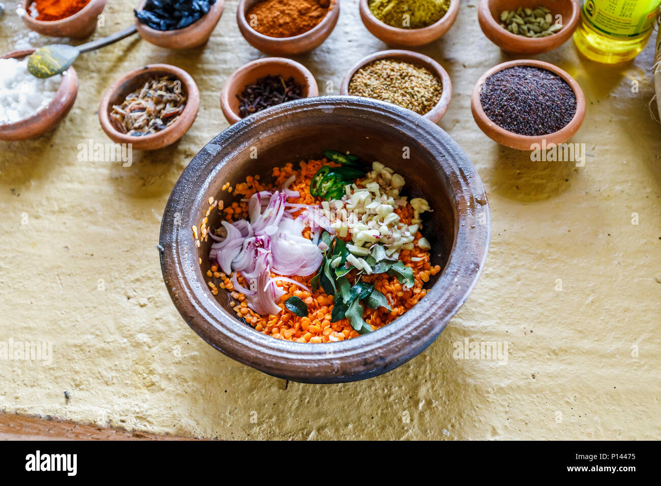 Bowl of ingredients for dahl to a traditional local recipe: lentils, chopped onions, garlic and leaves. Horagampita district, near Galle, Sri Lanka Stock Photo